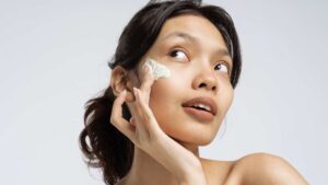 Femme qui se met de la crème sur le visage
